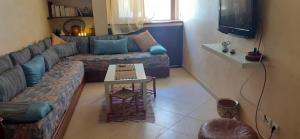 un salon avec un canapé et une table dans l'établissement Appartement dans résidence, à Martil