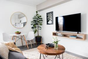 a living room with a flat screen tv on a wall at <THE MYLO> Walkable | Rooftop | Skyline | Dreamy in Atlanta +15 photos