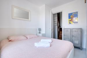 a white bedroom with a bed with towels on it at Maison typique Trouville, idéale famille in Trouville-sur-Mer