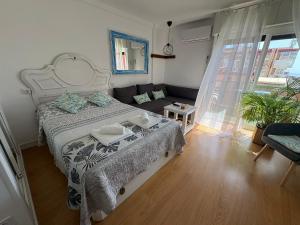 a bedroom with a large bed and a couch at SWEET HOME BENALMADENA Estudio para NO FUMADORES con vistas al mar y excelente conexion wifi NON SMOKING studio with sea views and excellent WiFi Enjoy plenty of morning sun in Benalmádena