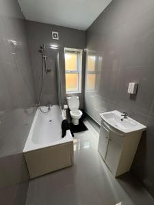 a bathroom with a black cat sitting in a bath tub at Tranquil 1BR in Gravesend in Gravesend