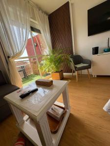 a living room with a table with a remote control on it at SWEET HOME BENALMADENA Estudio para NO FUMADORES con vistas al mar y excelente conexion wifi NON SMOKING studio with sea views and excellent WiFi Enjoy plenty of morning sun in Benalmádena