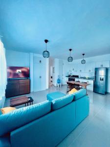 a living room with a blue couch and a kitchen at Mar Azul in Bayahibe +3 photos