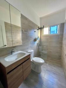 a bathroom with a sink and a toilet and a mirror at Mar Azul in Bayahibe