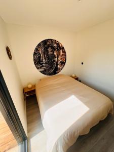 a bedroom with a bed with a poster on the wall at Buddha Cottage - PMR in Rosselange