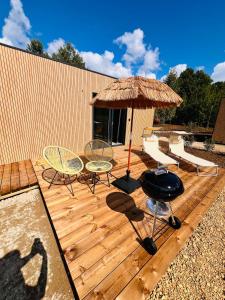 a wooden deck with a table and chairs and an umbrella at Buddha Cottage - PMR in Rosselange