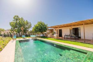 an image of a swimming pool in front of a house at Villa Yakout in Ghazoua