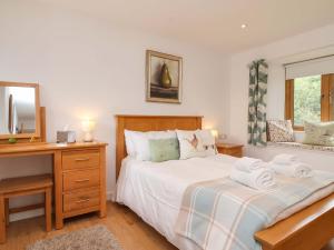 a bedroom with a bed and a desk and a mirror at Cawsand in Saltash