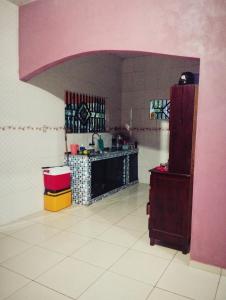 a kitchen with pink walls and a white tile floor at Casa com varanda in Barcarena