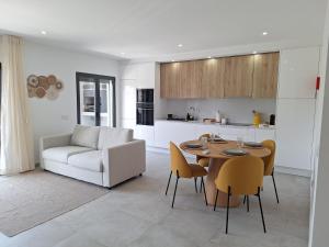 a kitchen and living room with a table and a couch at Edifício da Vinha - Ocean Breeze Apartments in Armação de Pêra
