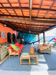 an outdoor living room with couches and a table at Conexão Hostel Ubatuba in Ubatuba