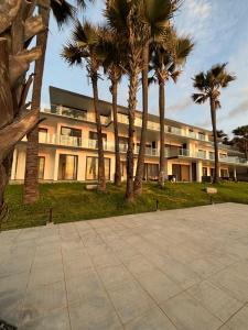 a building with palm trees in front of it at Stunning Oceanview 2B Waterfront Apartement in Bijilo