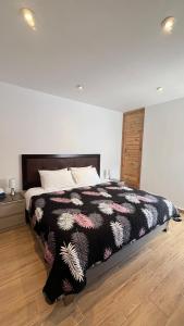 a bedroom with a bed with a black and white blanket at RANCH HAUS OXAPAMPA - PeT FRIENDLY in Oxapampa