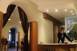 Un uomo in piedi al bancone in una stanza di Hotel Aspromonte a Milano