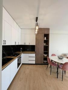a kitchen with white cabinets and a table and chairs at Apartment for daily rent in Tbilisi City