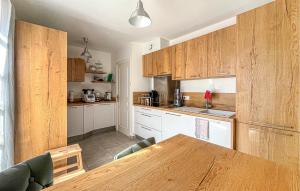 a kitchen with wooden cabinets and a wooden table at Villa Proche Cévennes in Saint-Hilaire-de-Brethmas