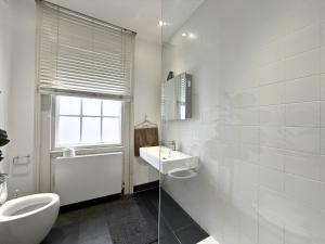 a white bathroom with a sink and a toilet at Posh Soho Studio Large Windows by Oxford St, Mayfair W1 in London +21 photos