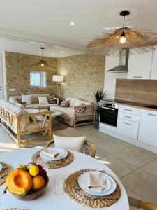 una cucina e un soggiorno con tavolo e frutta di LES MAISONS DE GIROUDET 2 chambres terrasse et piscine a Écrosnes