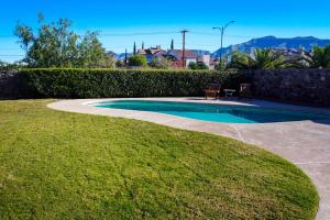 a swimming pool with two chairs next to a yard at El Paso Retreat with Pool 11 Mi to Downtown! in El Paso