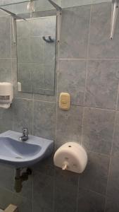 een badkamer met een wastafel en een spiegel bij Hostal El Amanecer Costero in Santa Marta