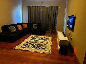 a living room with a couch and a tv at Goshen in Johannesburg