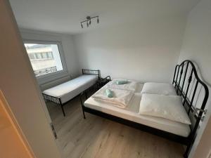 a small bedroom with two beds and a window at Monteurwohnung mit Balkon und 4-Zimmern in Pforzheim +5 photos