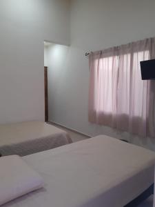 una camera da letto con due letti e una finestra di Casa Herrera a Santa Cruz Huatulco