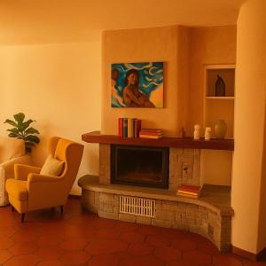 a living room with a fireplace and a chair at Casa al Sasso in Bellinzona