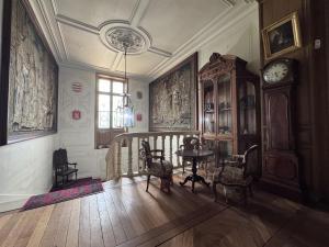una stanza con tavolo e orologio a pendolo di Chateau de Resteau Haut de Gamme 15 pers a Maigné
