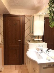 a bathroom with a sink and a mirror and a door at Il GIGLIO in Ponte di Legno +17 photos