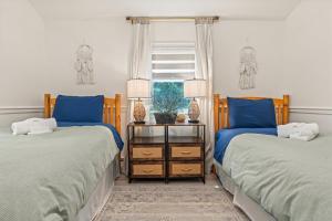 deux lits dans une chambre avec des oreillers bleus et une fenêtre dans l'établissement Quiet Cottage In The Woods, On A Country Road, à Glenmoore