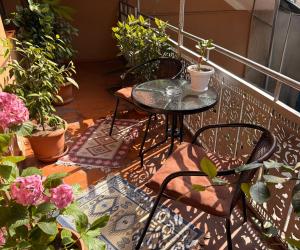 a balcony with two chairs and a table and potted plants at SDD Brothers - Дом с балконом в сердце Тбилиси in Tbilisi City