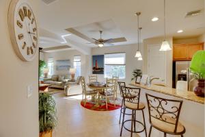 埃斯特罗Calming Estero Home with Community Pool and More!的厨房以及带墙上时钟的客厅。