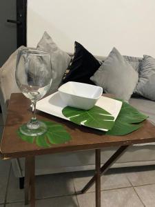 einen Tisch mit einem Glas Wein und einer Schüssel darauf in der Unterkunft Departamento Coral in Lo de Marcos