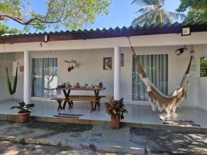 a house with a hammock in front of it at Rancho Dias in Atins