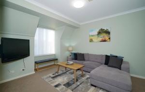 a living room with a couch and a tv at 40 Modern & Chic Apt In East Perth in Perth +3 photos