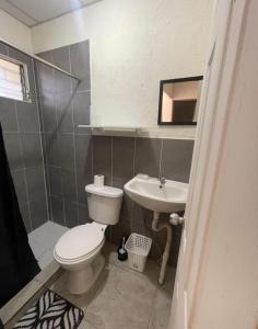 un baño con inodoro y lavabo en Casa amplia y cómoda, en Nueva San Salvador