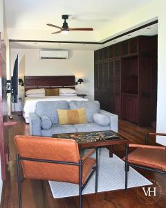 Un dormitorio con una cama, un sofá y una mesa. en The Bougainvillea Studio at Villa Horizon, en Rodney Bay Village