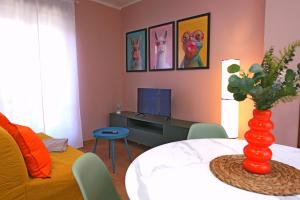 a living room with a table with a vase at Maison dans la rue in Gassino Torinese