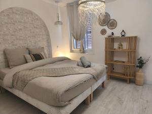 una camera da letto con un letto grande e un lampadario di Perle Rare du Centre-ville a Évreux