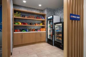 a store aisle with a refrigerator in a store at Holiday Inn Express & Suites Muskegon - Grand Haven by IHG in Muskegon