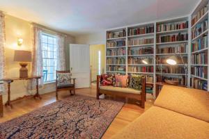 una sala de estar con una gran biblioteca con estanterías de libros en Picture Postcard Mansion In Manchester Village, en Manchester