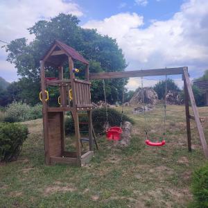 ein Spielplatz mit einer Schaukel auf einem Feld in der Unterkunft Апартамент "Rodopi" с Гледка към Езеро Безплатен Подземен Гараж in Smoljan + 61 Fotos