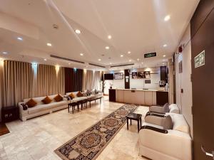 a large living room with couches and a kitchen at فندق الرسالة الفندقية ذاخر توصيل مجاني من والى الحرم Al-Risala Hotel Zakhar Free delivery to and from the Haram in An Naqāʼ