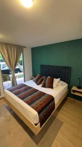a bedroom with a large bed with a green wall at Casa Turística Don Juan in Ibagué