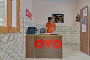 a man standing at a noo counter in a store at Hotel O by OYO Happy Homes in New Delhi