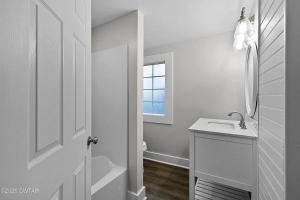 a white bathroom with a sink and a window at Campbell Street Charm in Jackson +9 photos
