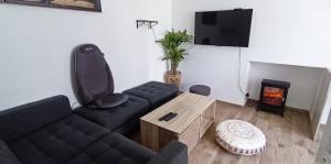 ein Wohnzimmer mit Sofa und Kamin in der Unterkunft Le Ptit Cottage in Landivisiau