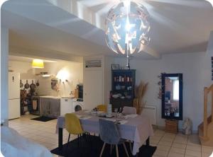 a dining room with a table with chairs and a chandelier at Chez ISA chambre chez l'habitant Léa in Montlouis-sur-Loire