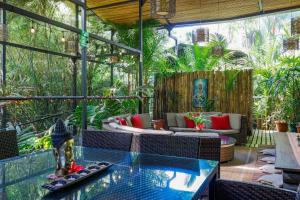 an outdoor patio with a glass table and chairs at Danyasa Eco-Retreat in Dominical +13 photos